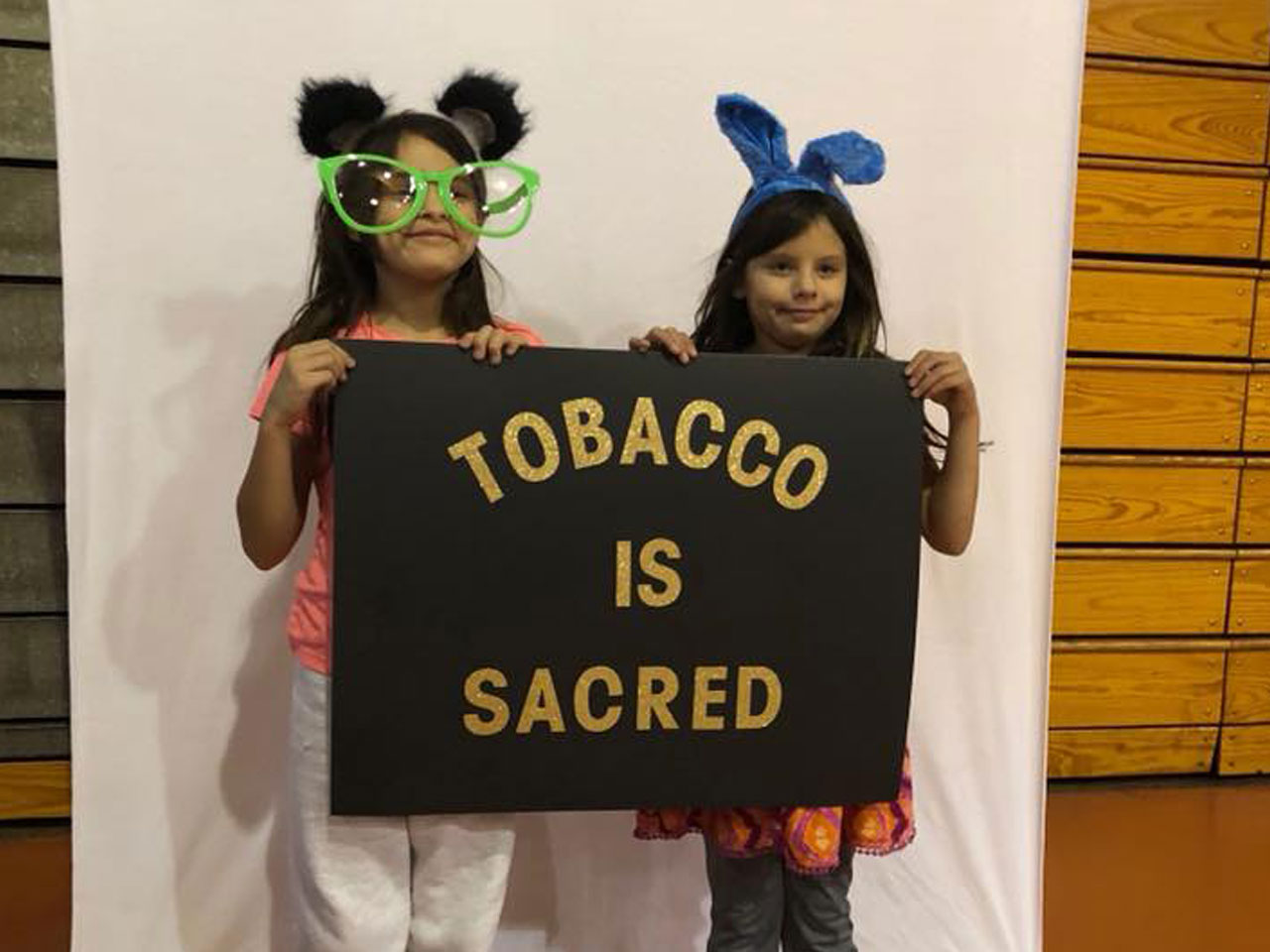 Two girls with Tobacco is Sacred Sign