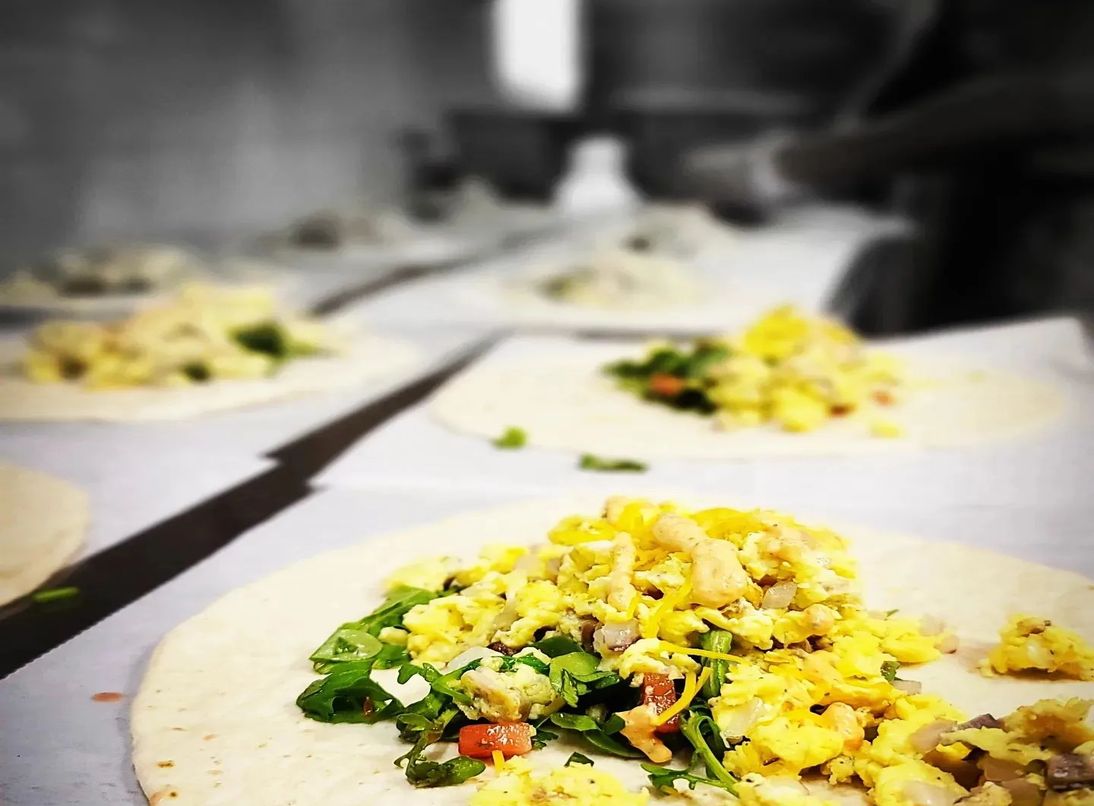 A table of breakfast tacos with eggs.